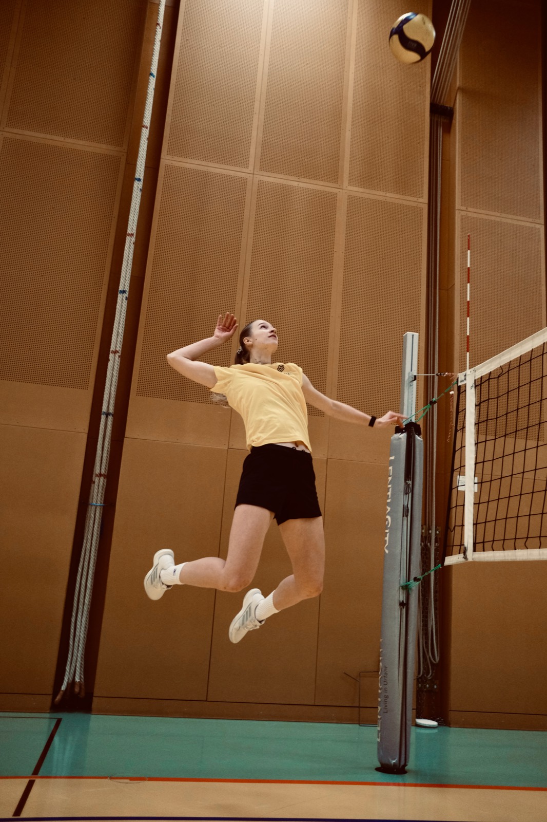 Volleyball player jumping at net