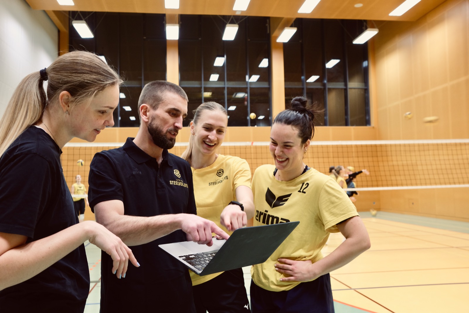 Coach showing players tactics on laptop